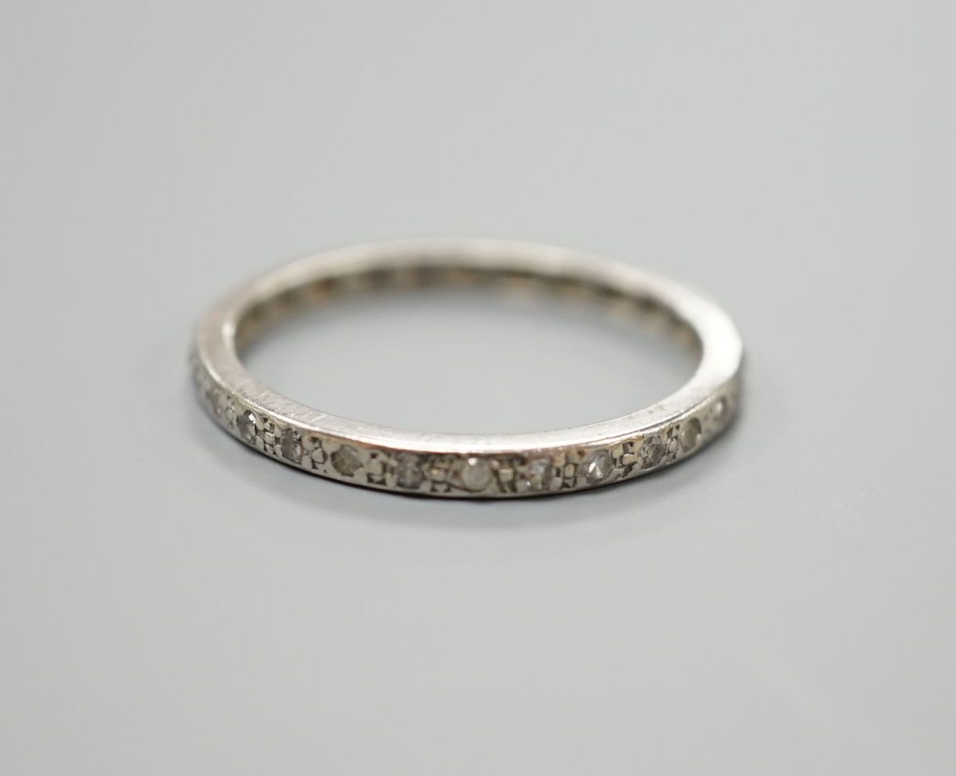 A white metal and diamond chip set full eternity ring, size O/P, gross weight 2.4 grams.